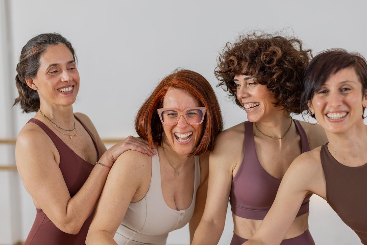 Vier vrouwen trainen en lachen samen in een studio